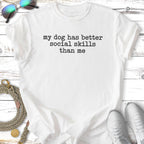 White t-shirt with "my dog has better social skills than me" text.