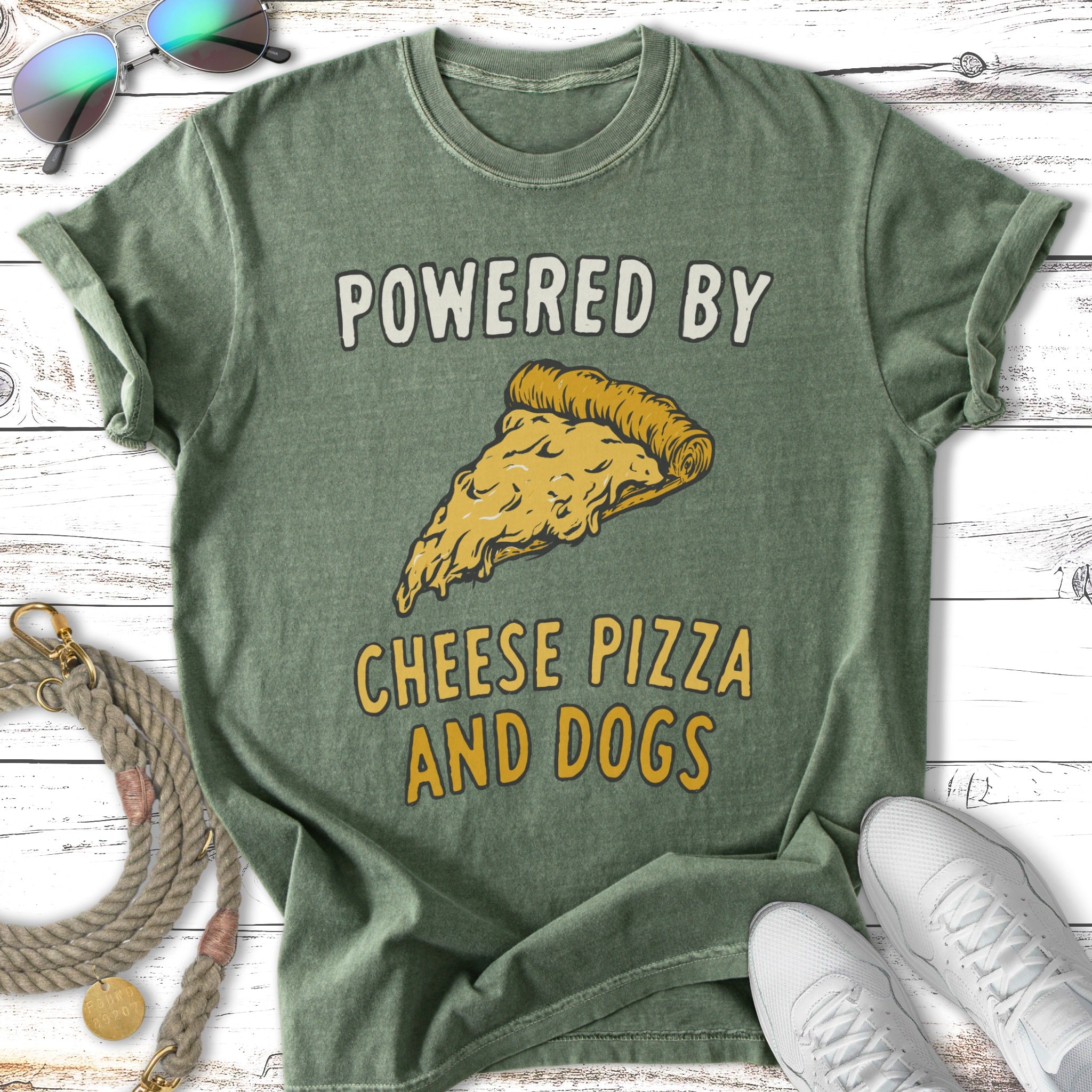 Green t-shirt with "POWERED BY CHEESE PIZZA AND DOGS" text and pizza slice graphic.