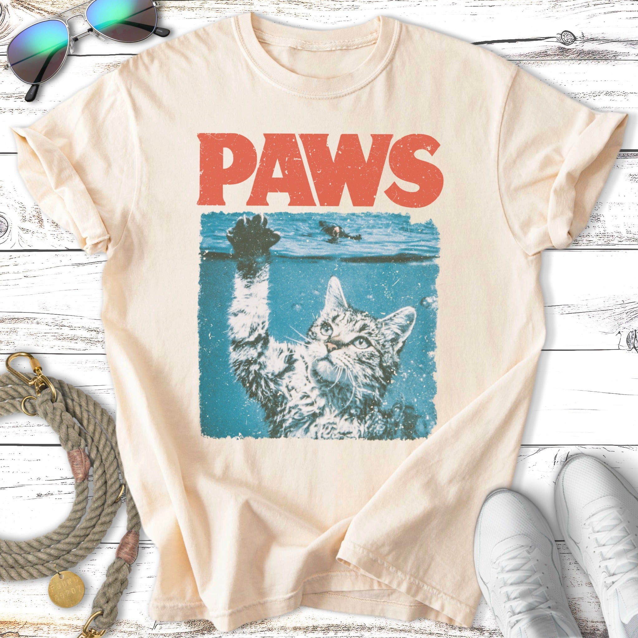 Cat reaching up from water with "PAWS" text above.