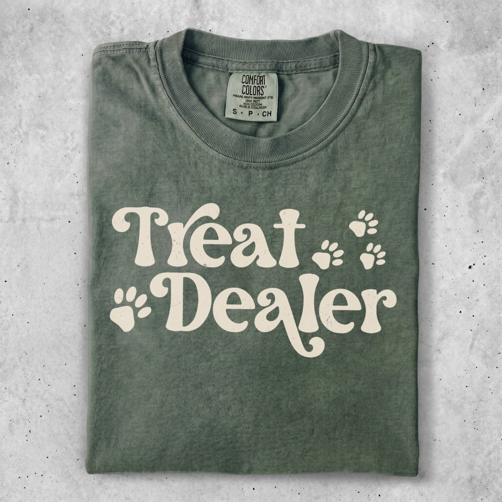 Green t-shirt with "Treat Dealer" and paw prints in cream.