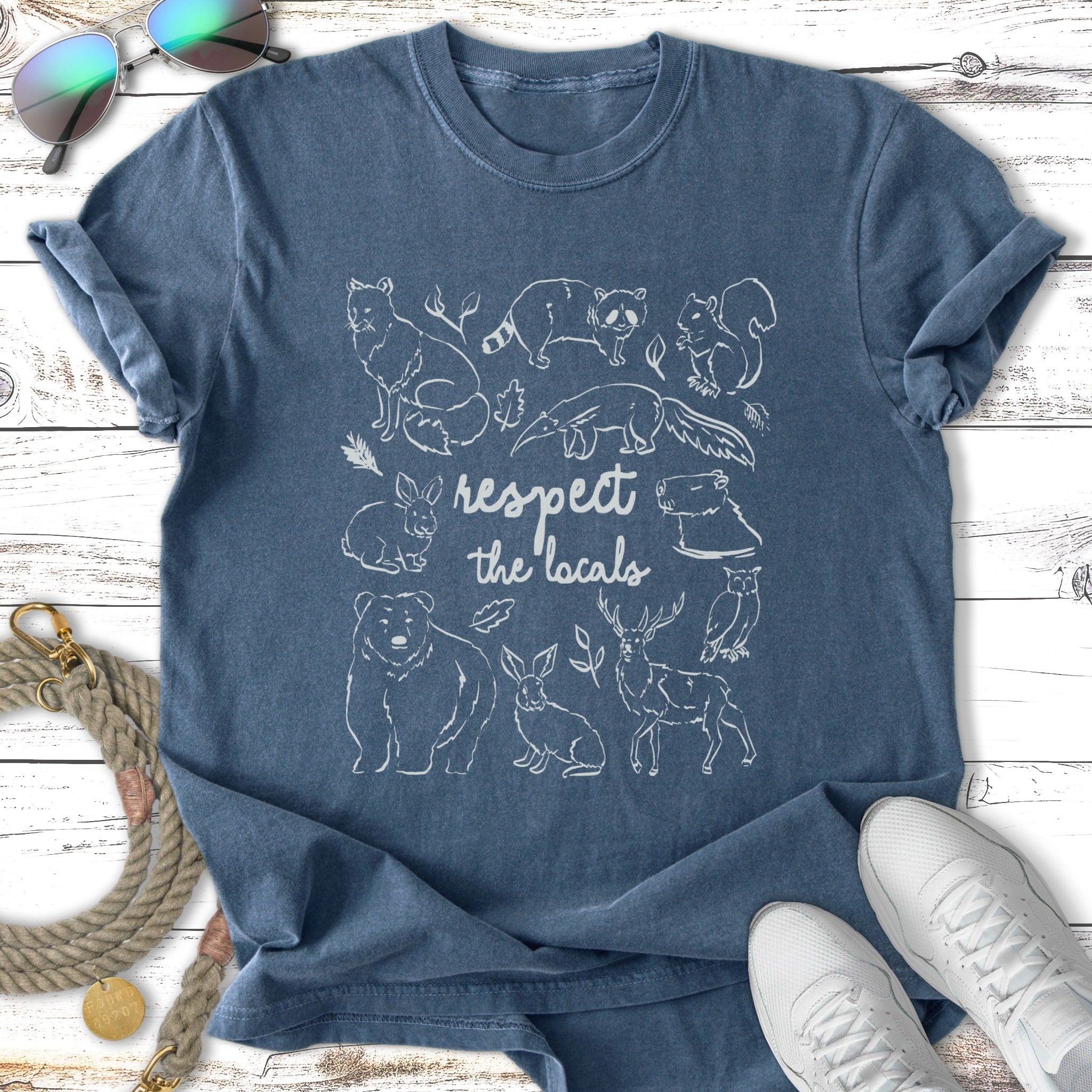 T-shirt with white line drawings of local wildlife and "respect the locals" text.