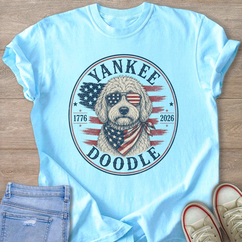 Light blue t-shirt with a round graphic featuring a doodle dog wearing sunglasses and bandana.