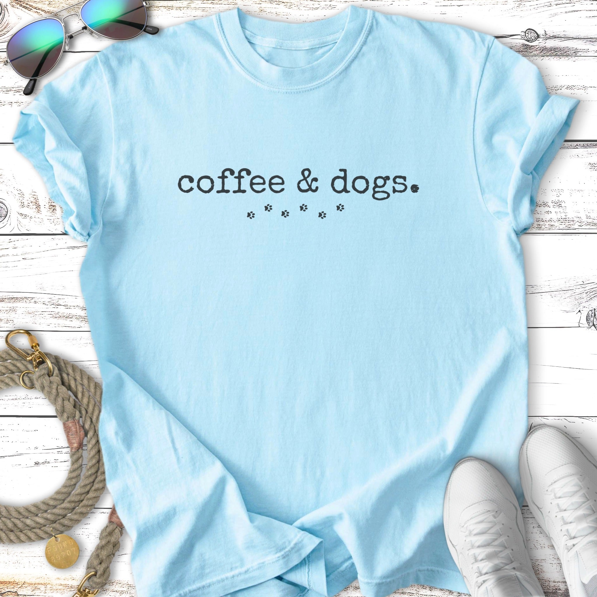 Light blue t-shirt with "Coffee & dogs." and paw print graphic.