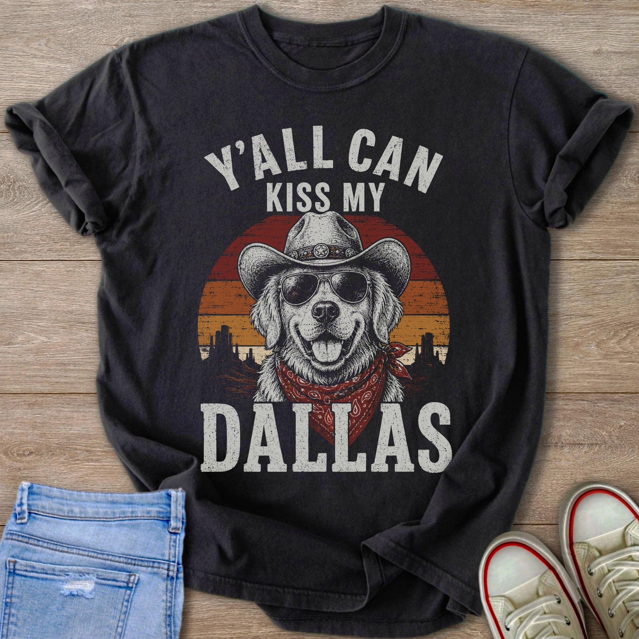 Black t-shirt featuring a dog in a cowboy hat, sunglasses, and bandana with text "Y'all Can Kiss My Dallas".