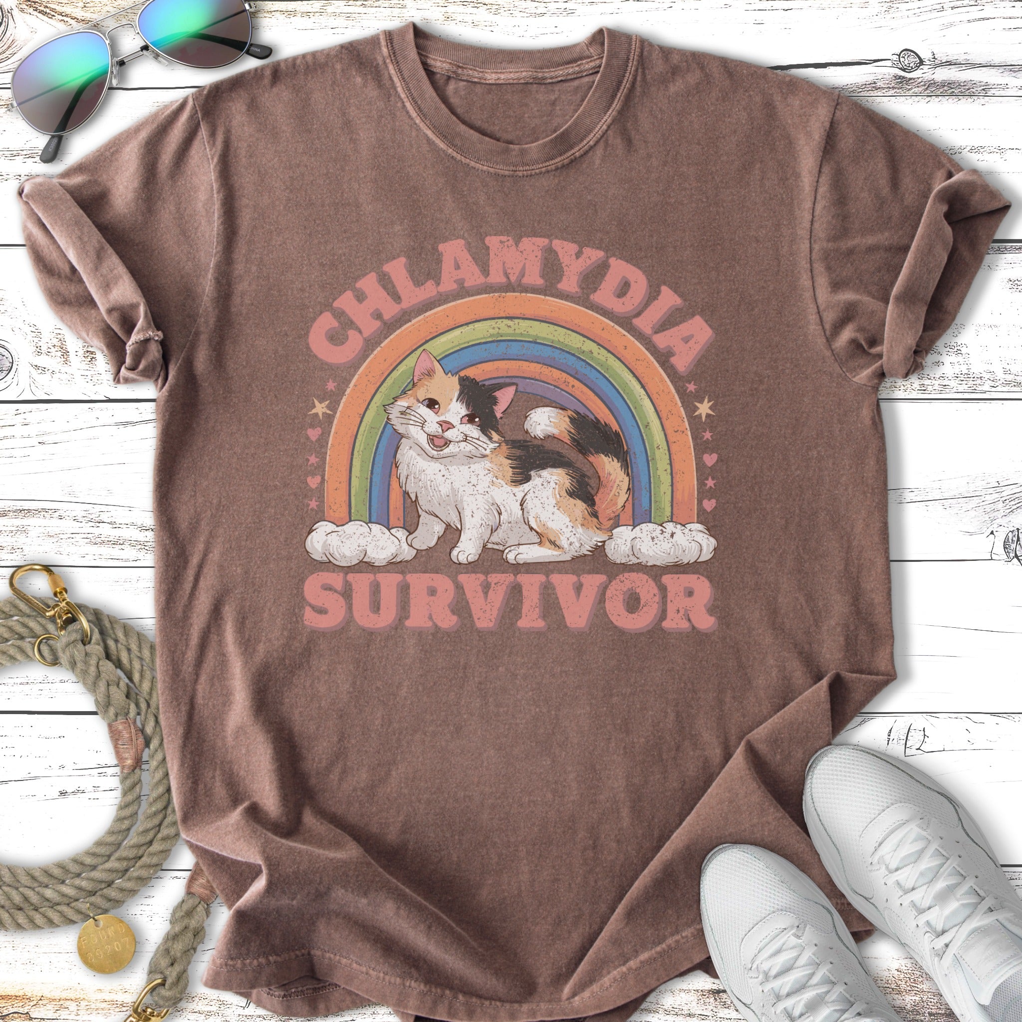 T-shirt with cat, rainbow, and clouds, reading "Chlamydia Survivor".