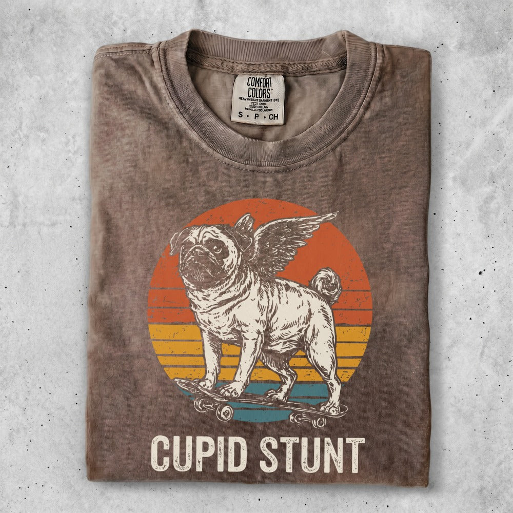 Pug with wings on a skateboard, vintage sunset, "CUPID STUNT" text.