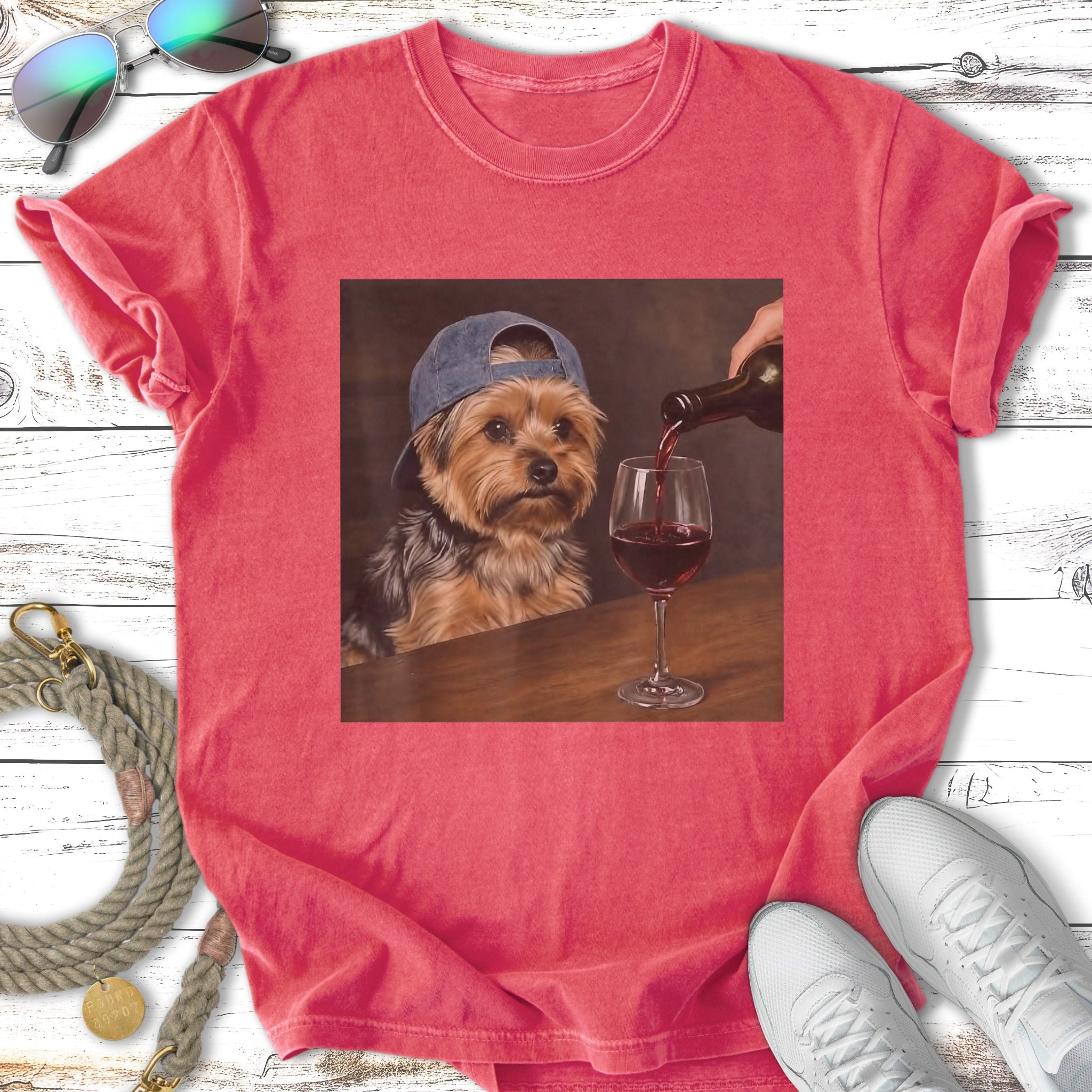 Yorkshire terrier wearing a baseball cap, being poured wine into a glass.