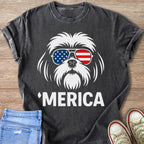 Dark t-shirt with white graphic of a dog wearing American flag sunglasses and text 'Merica.