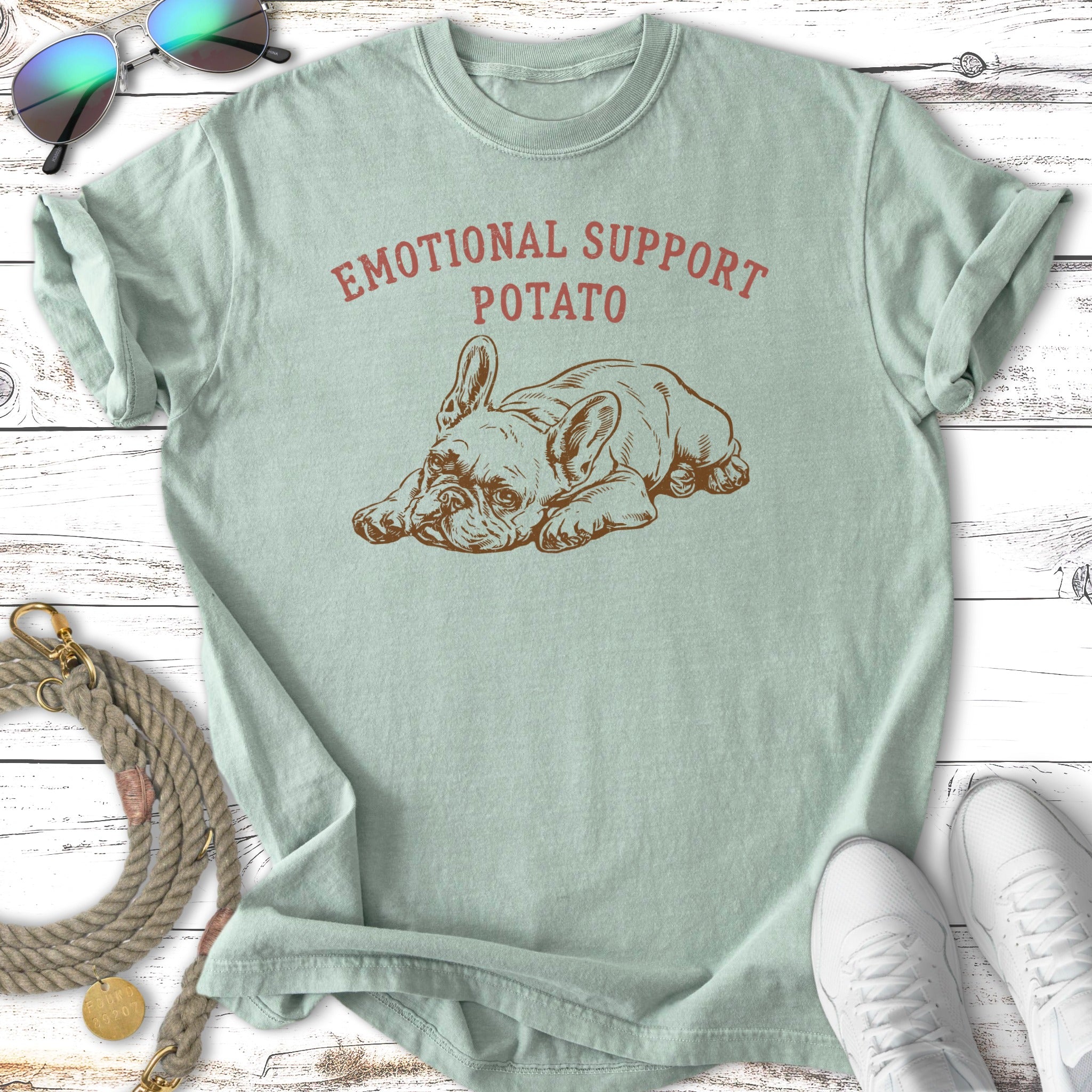 French bulldog with "Emotional Support Potato" text on a pale green t-shirt.