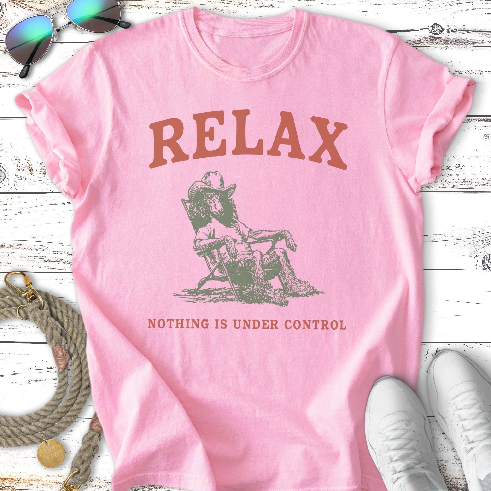 Pink t-shirt with "RELAX NOTHING IS UNDER CONTROL" text and a reclining cowboy graphic.