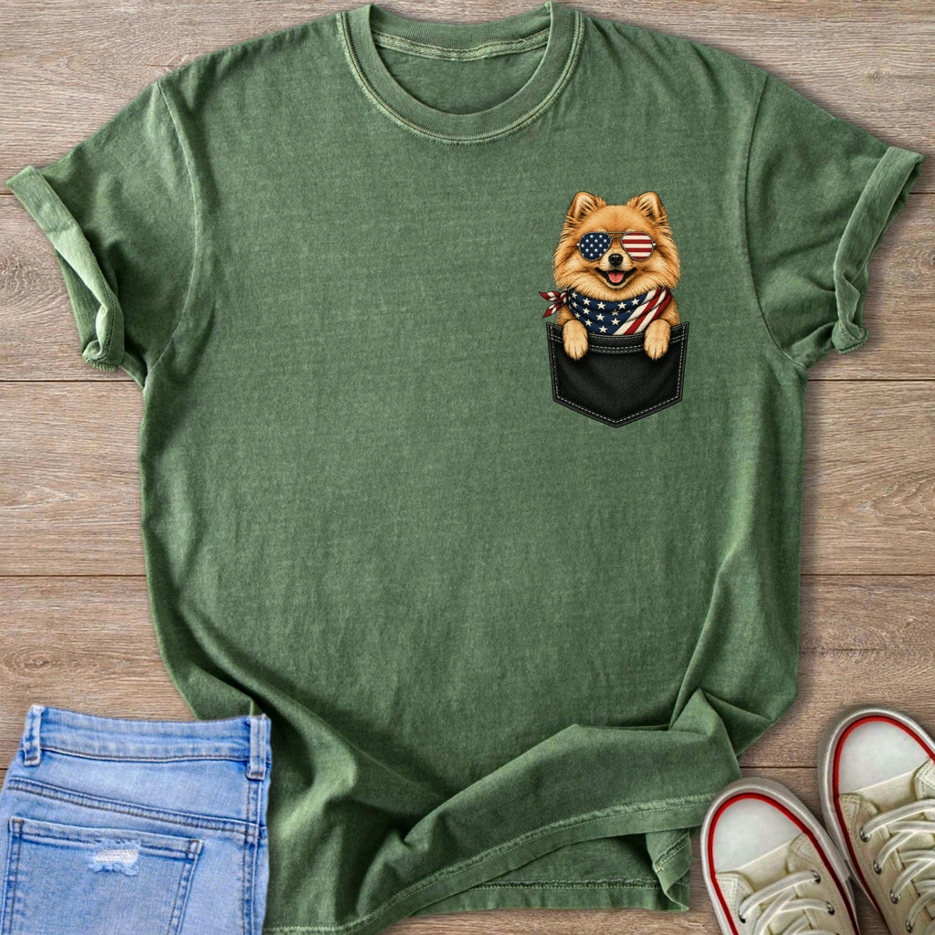 Green t-shirt with a Pomeranian dog wearing American flag sunglasses peeking from pocket.