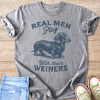 Grey t-shirt with a dachshund graphic and text "Real Men Play With Their W**ners".