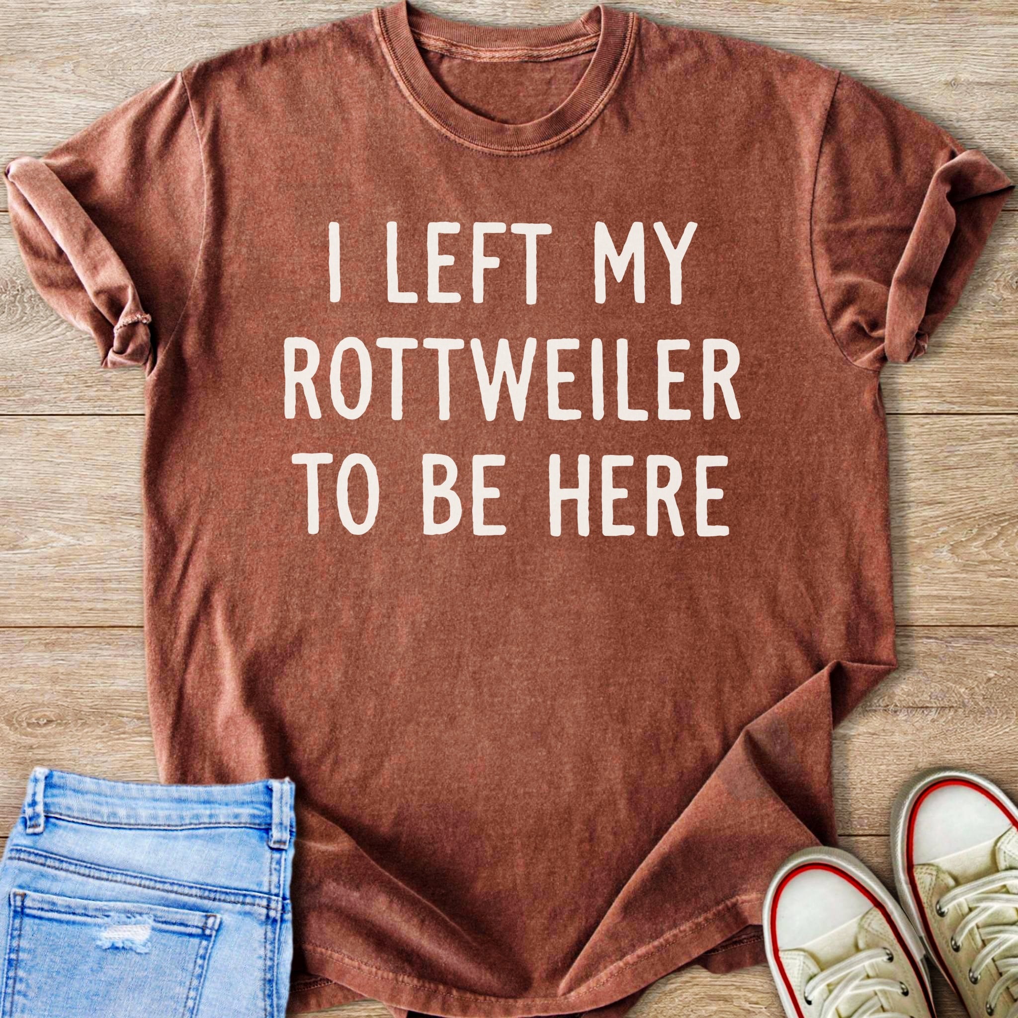 Brown t-shirt with white text "I LEFT MY ROTTWEILER TO BE HERE".