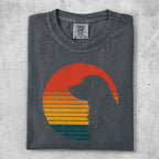 Dark t-shirt with a dog silhouette against a colorful sunset graphic.