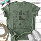 Nine sketched kittens in various poses on a green t-shirt.