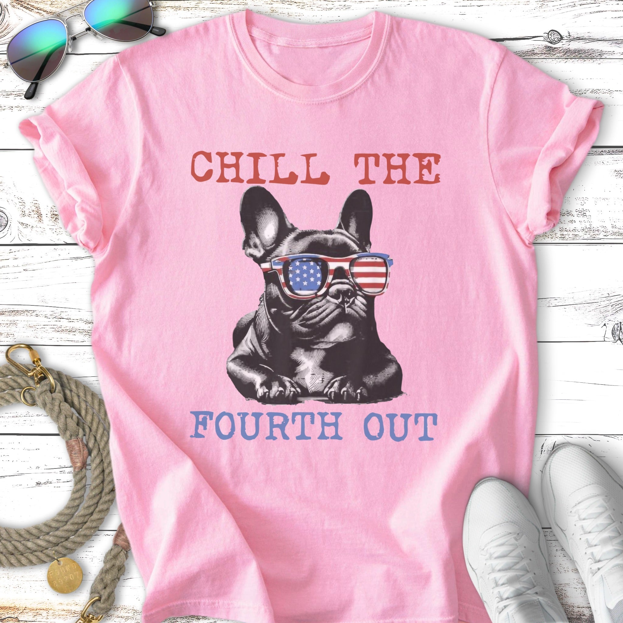 French bulldog wearing American flag sunglasses on pink t-shirt with "Chill The Fourth Out" text.