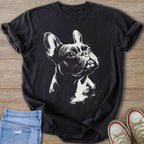 Dark t-shirt with a white ink sketch of a French Bulldog on a wooden surface.