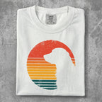 White t-shirt with a retro-style dog silhouette and sunset stripes.