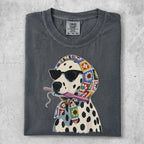Dalmatian dog wearing sunglasses and a colorful crocheted scarf holding a crochet hook.