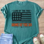 Teal t-shirt with distressed American flag graphic featuring paw prints and "Land of the Free Home of the K9".