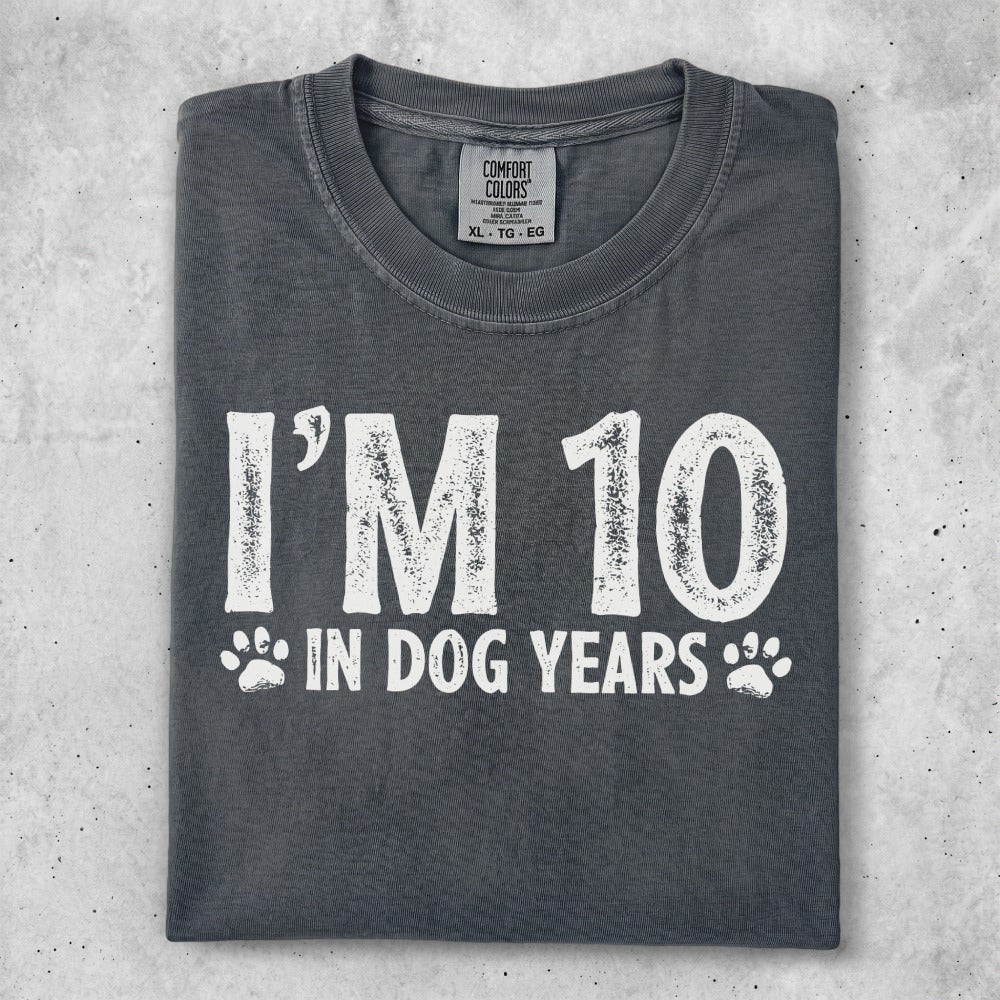 "I'm 10 in dog years" graphic tee on a dark grey shirt.