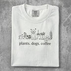 White t-shirt with "plants. dogs. coffee." text and line art.