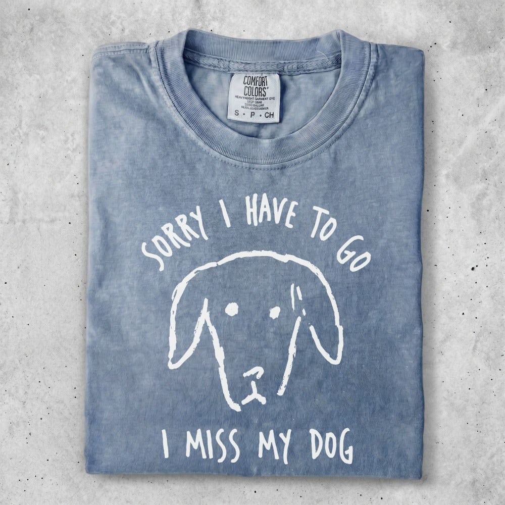 Blue t-shirt with "Sorry I have to go I miss my dog" text and dog illustration.