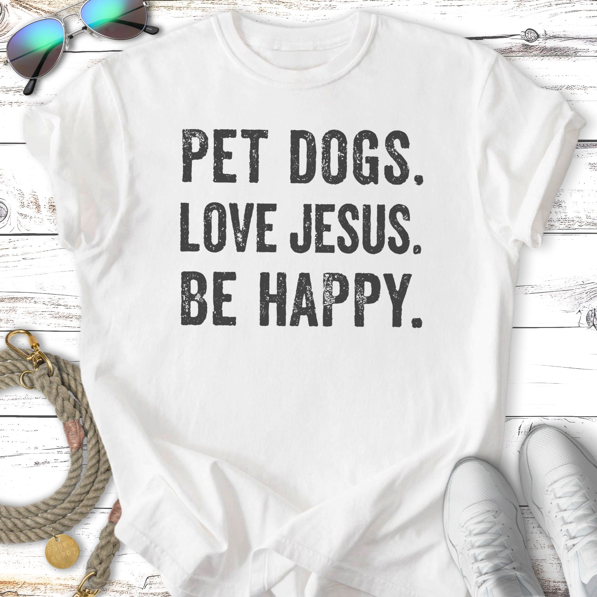 White t-shirt with "PET DOGS. LOVE JESUS. BE HAPPY." text.