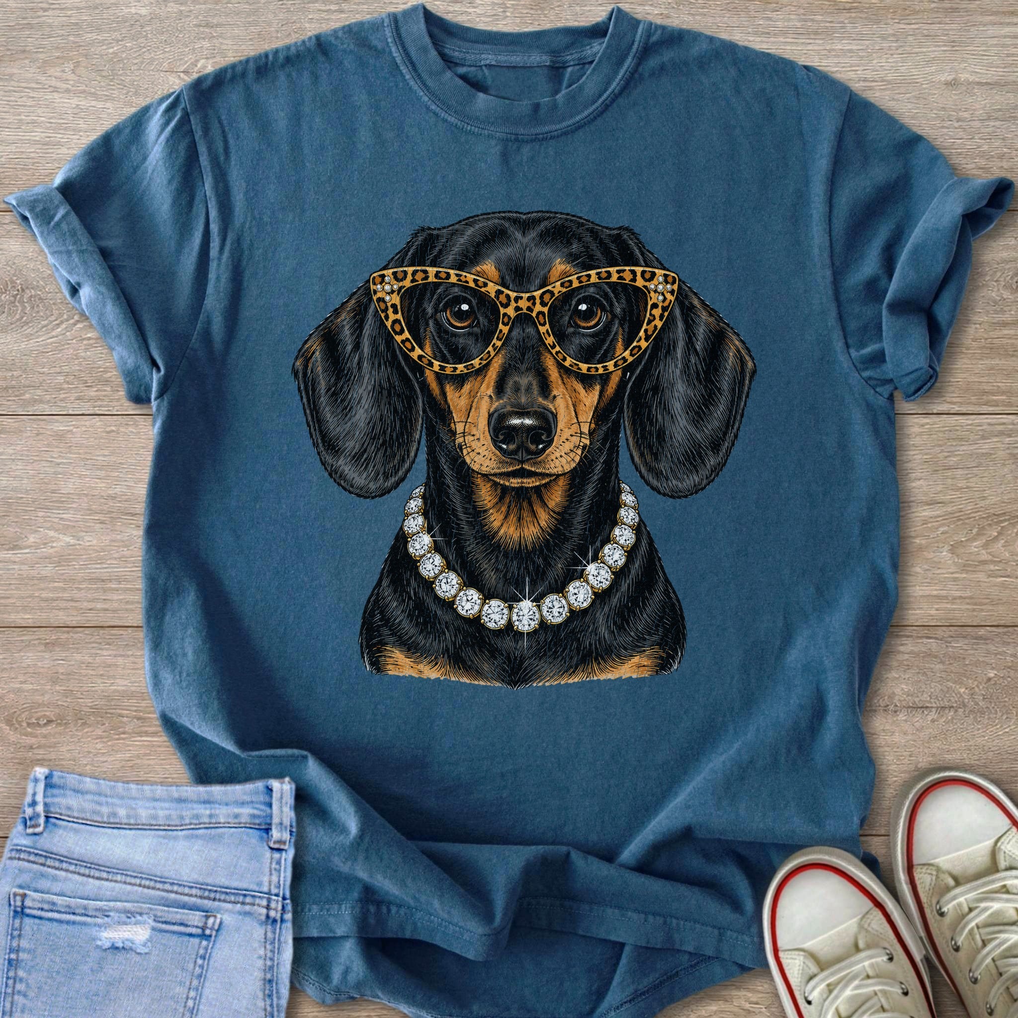 Dachshund with leopard glasses and diamond necklace graphic on blue tee.