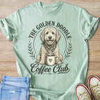 Golden Doodle wearing bandana sits with coffee mug, text "The Golden Doodle Coffee Club".