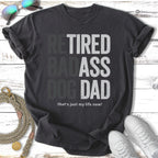 Dark grey t-shirt with "Retired Badass Dog Dad that's just my life now!" text.