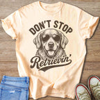 Peach t-shirt with graphic of dog wearing sunglasses and text "Don't Stop Retrieving."