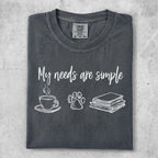 Gray t-shirt with "My needs are simple" and icons for coffee, paw print, and books.