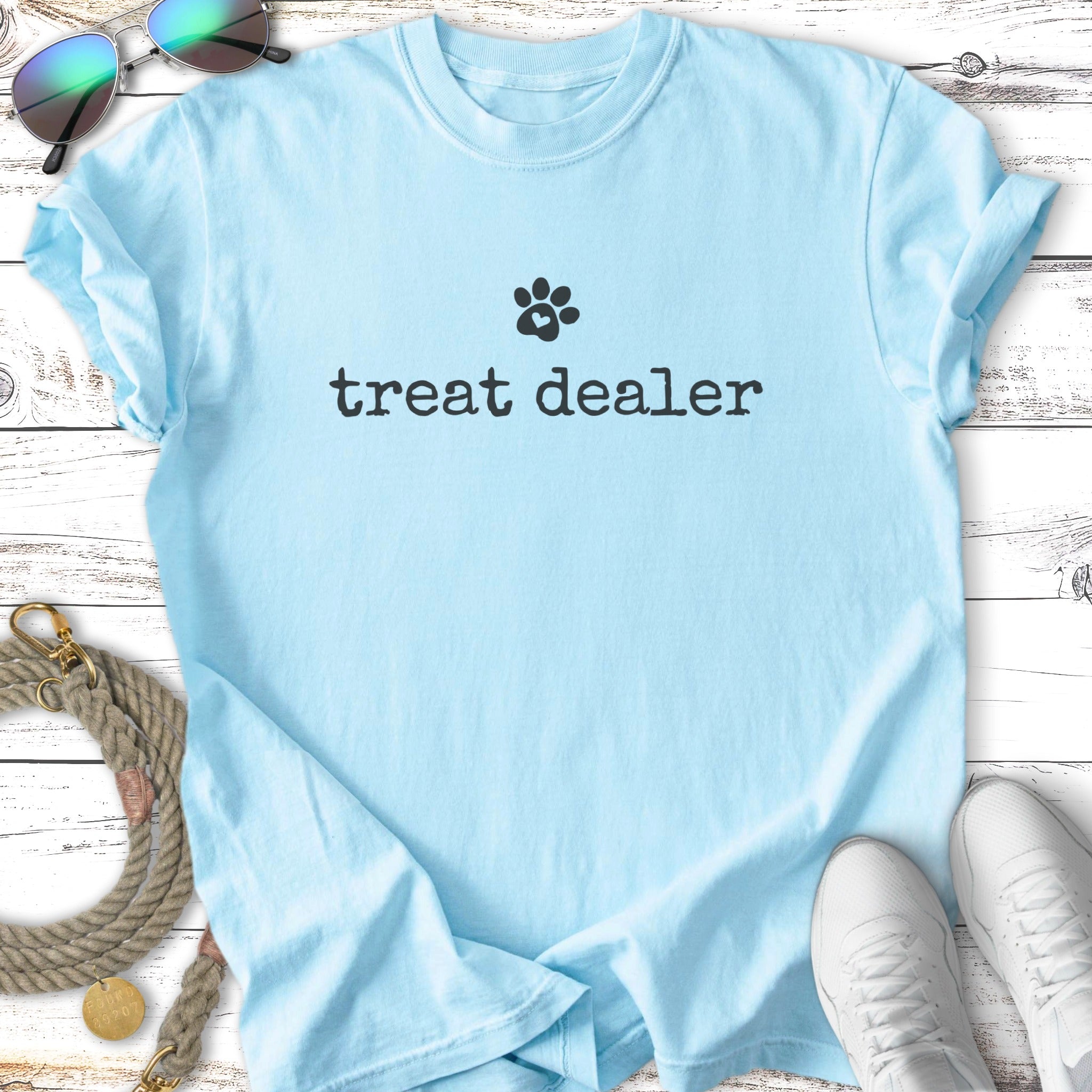 Light blue t-shirt with "treat dealer" and a paw print logo.