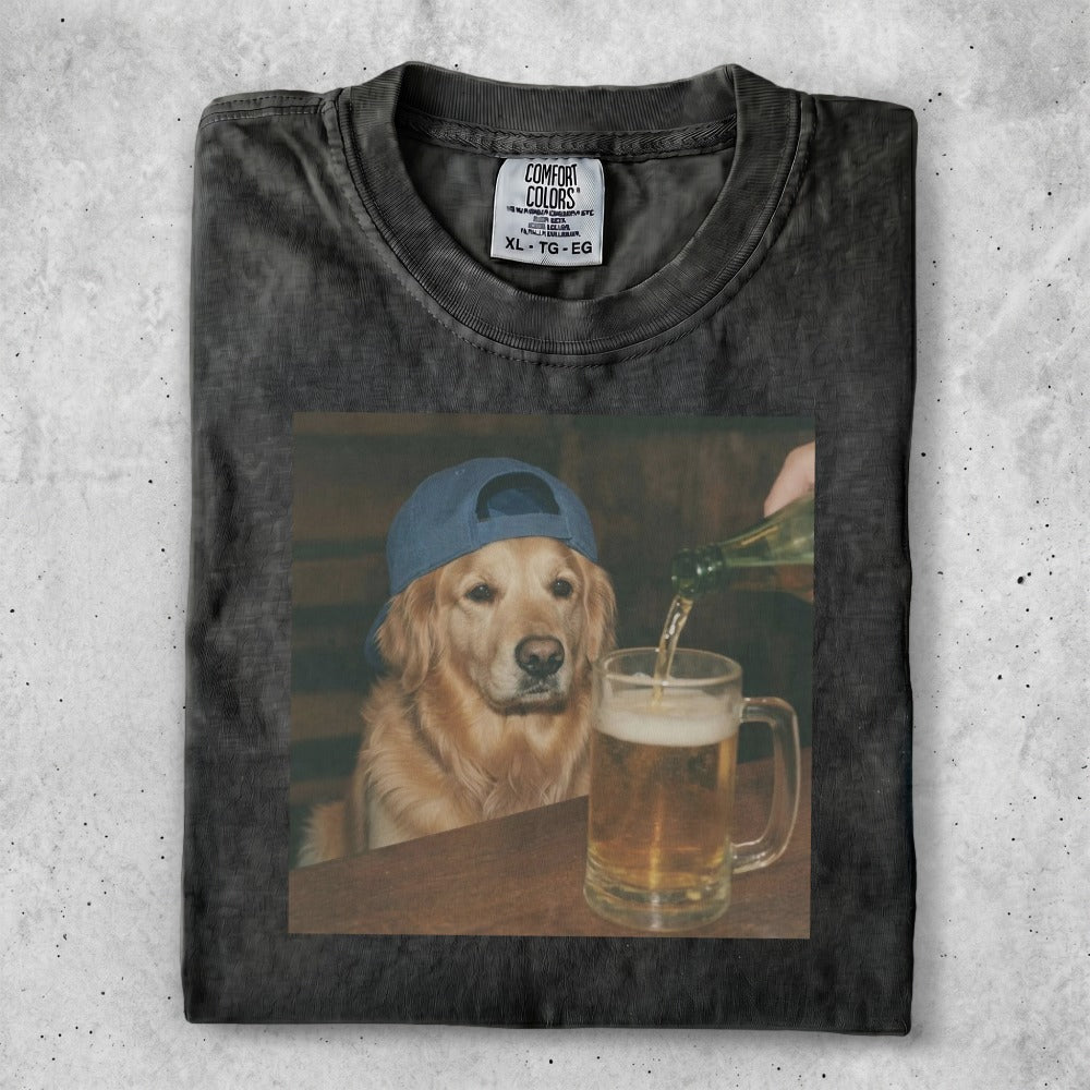 Black t-shirt with a golden retriever wearing a blue baseball cap and being poured a beer.