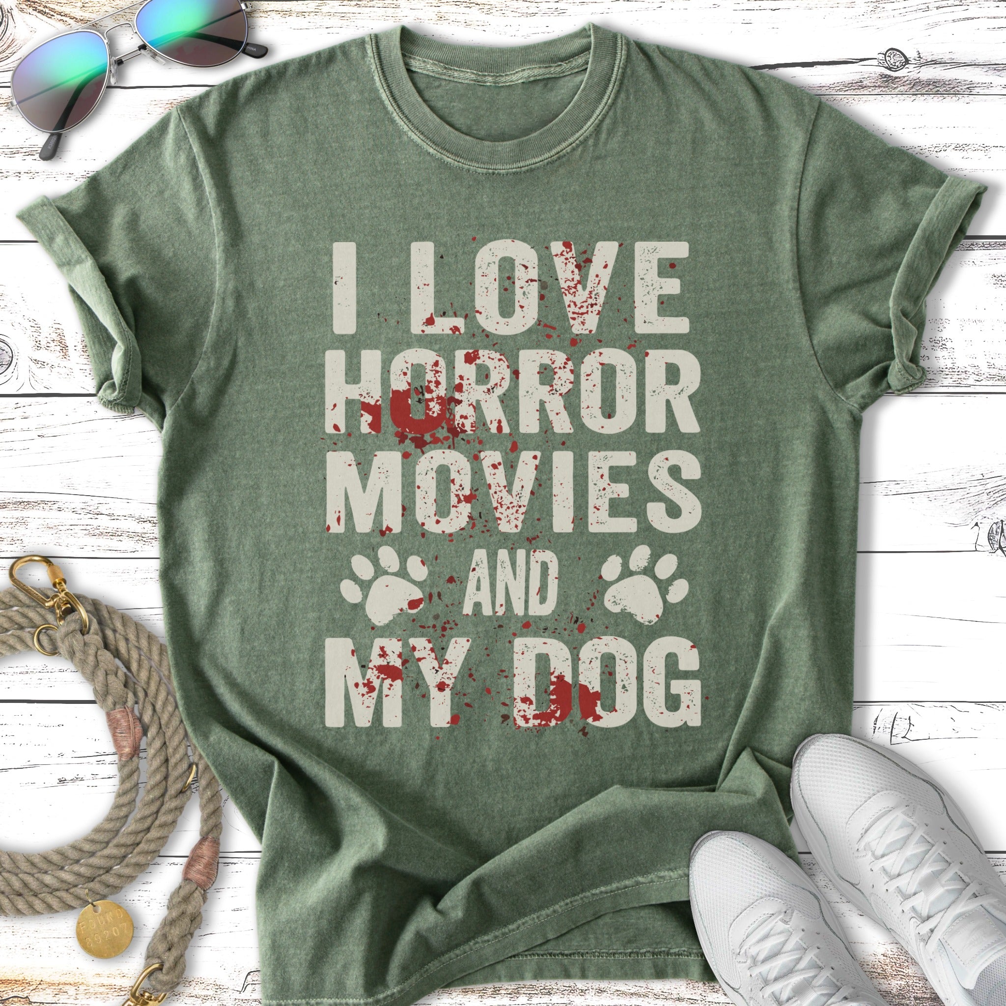 Green t-shirt with "I love horror movies and my dog" text and paw prints.
