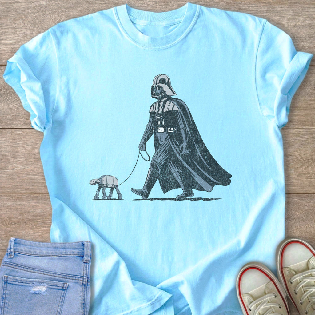 Darth Vader walks an AT-ST on a leash, a humorous graphic on a light blue t-shirt.