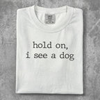 White t-shirt with "hold on, i see a dog" text.