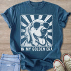 Blue t-shirt with white graphic of a smiling golden retriever wearing sunglasses.