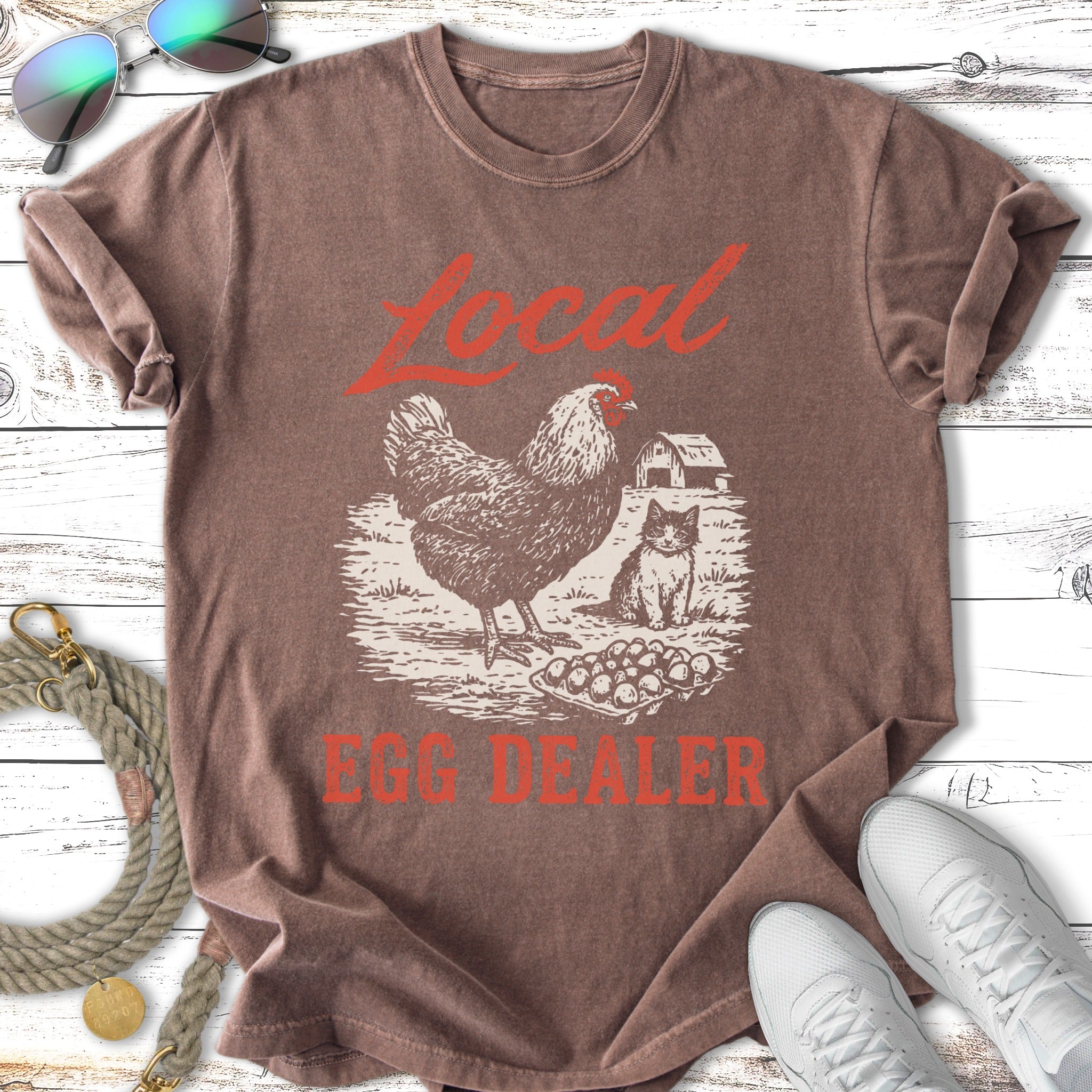 Chicken and kitten graphic on brown t-shirt, "Local Egg Dealer" text.