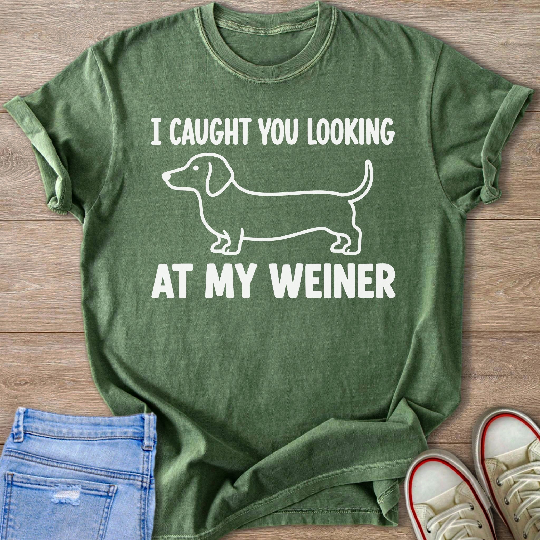 Green t-shirt with white outline of a dachshund and text reading "I CAUGHT YOU LOOKING AT MY WEINER".