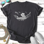 Dark t-shirt with a white stylized drawing of a fluffy dog in a rocky landscape.