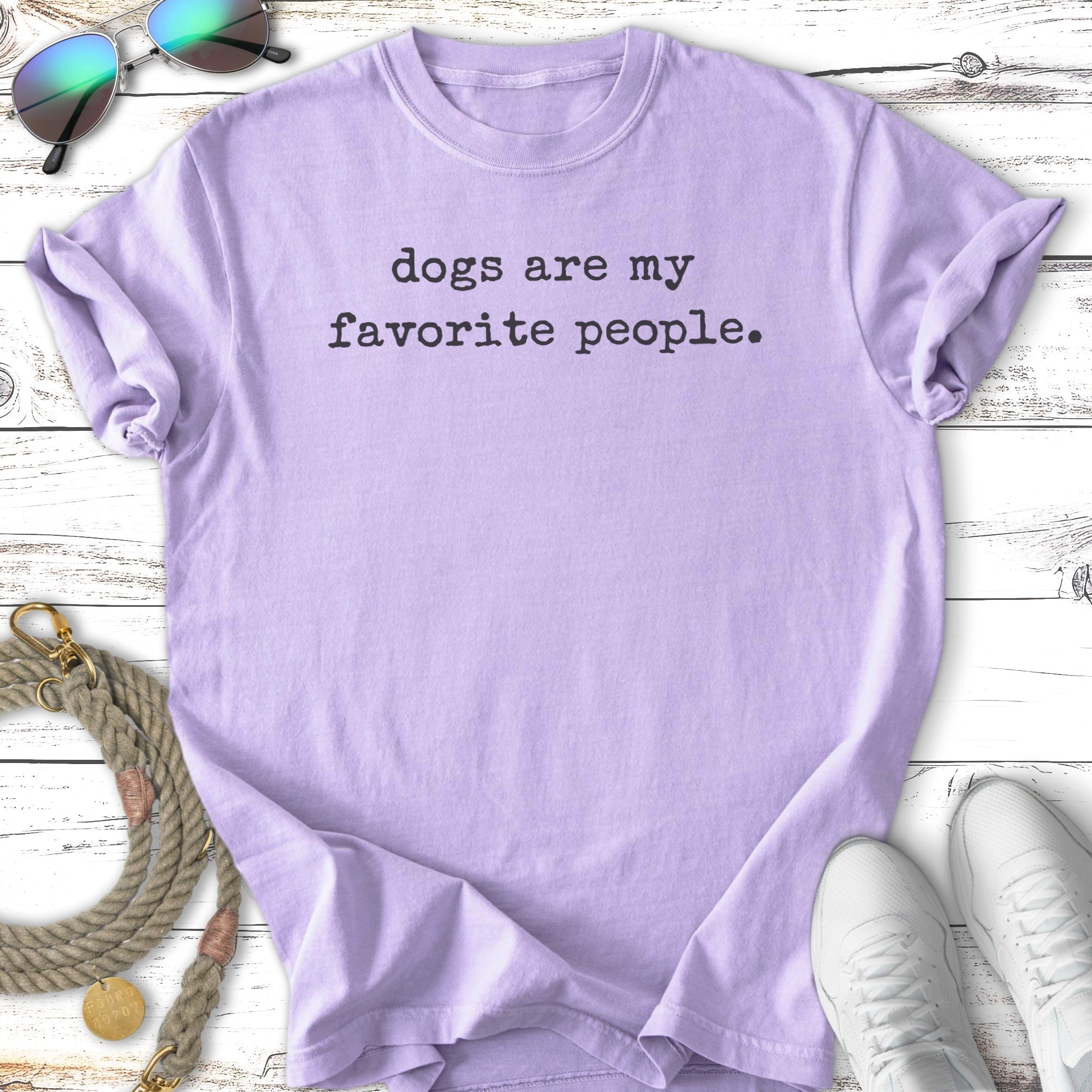 Lavender t-shirt with "dogs are my favorite people" text, sunglasses, and sneakers.
