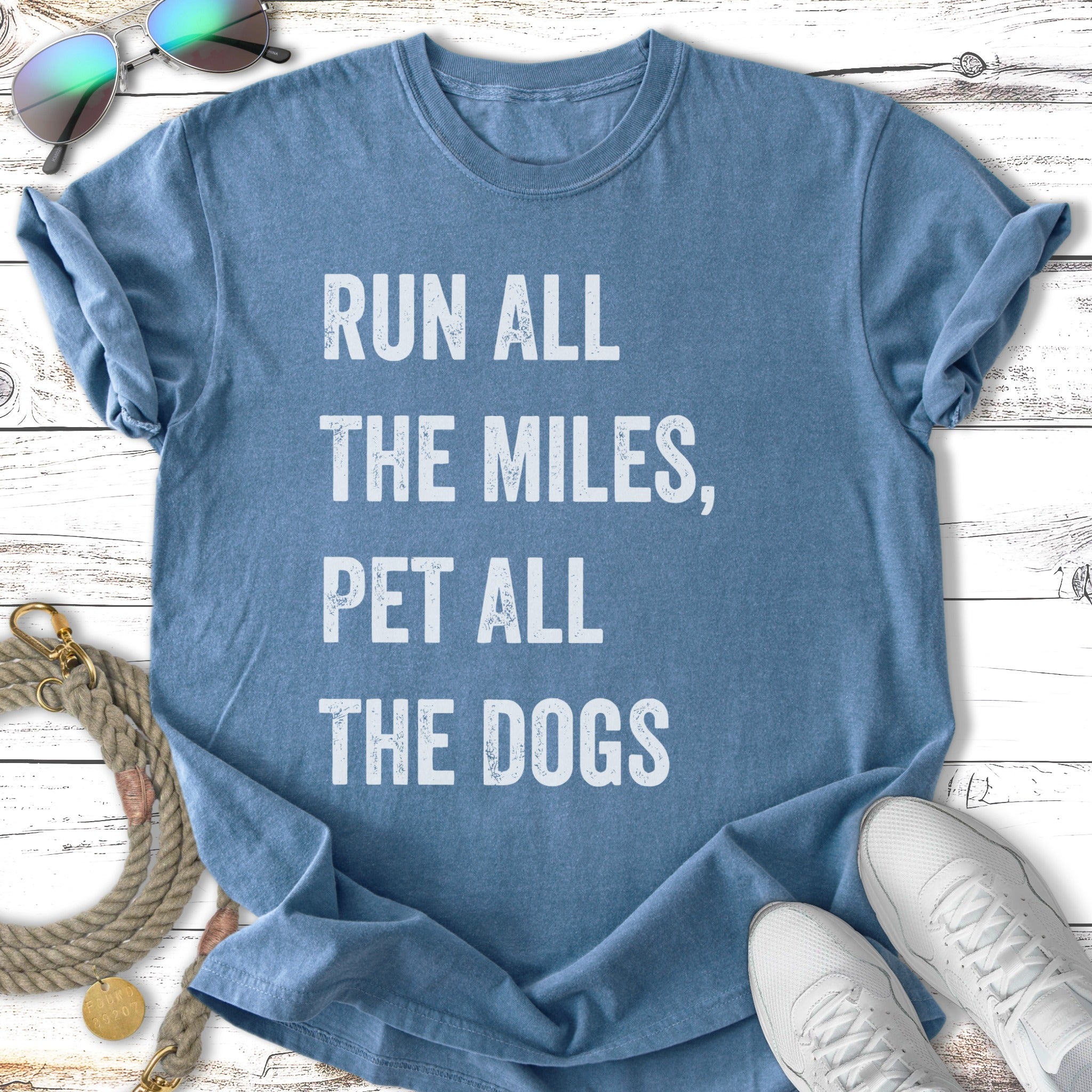 Blue t-shirt with text "Run All The Miles, Pet All The Dogs".