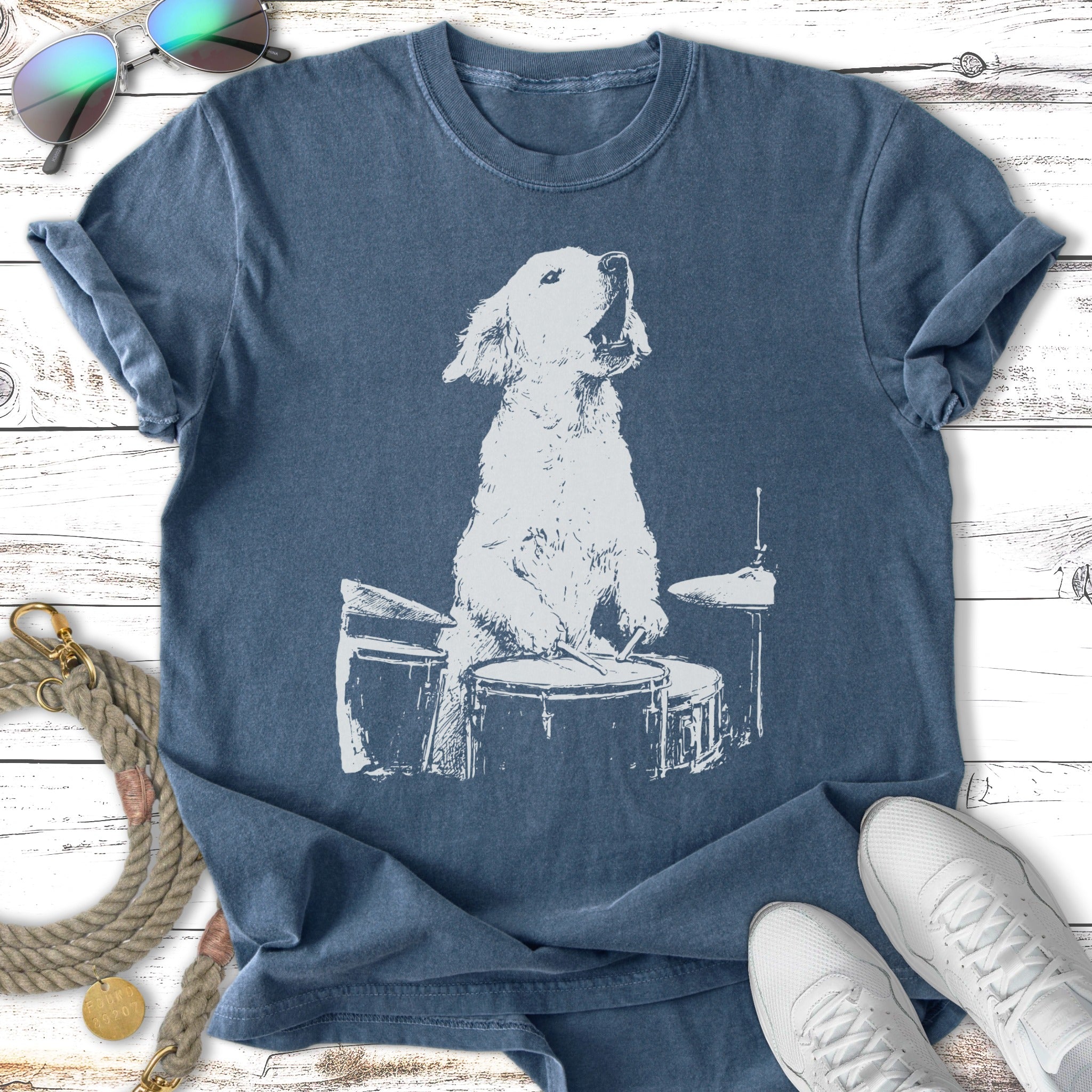 Golden Retriever puppy playing drums graphic on a faded blue t-shirt.