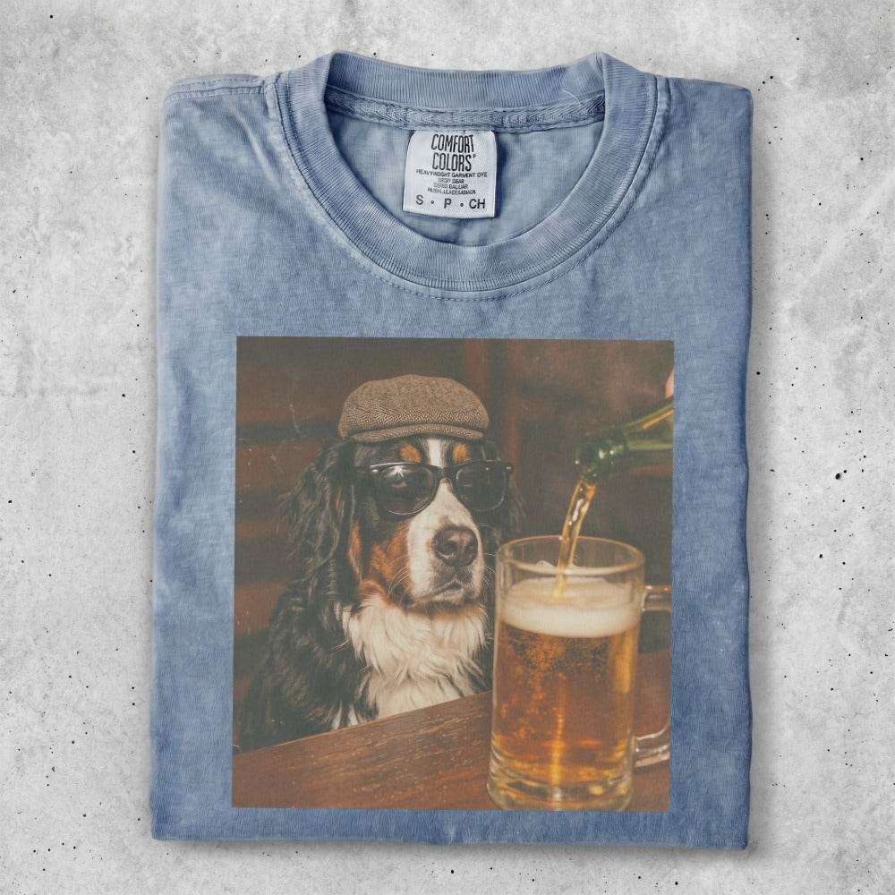 Bernese Mountain Dog wearing sunglasses and a cap, with a beer poured.