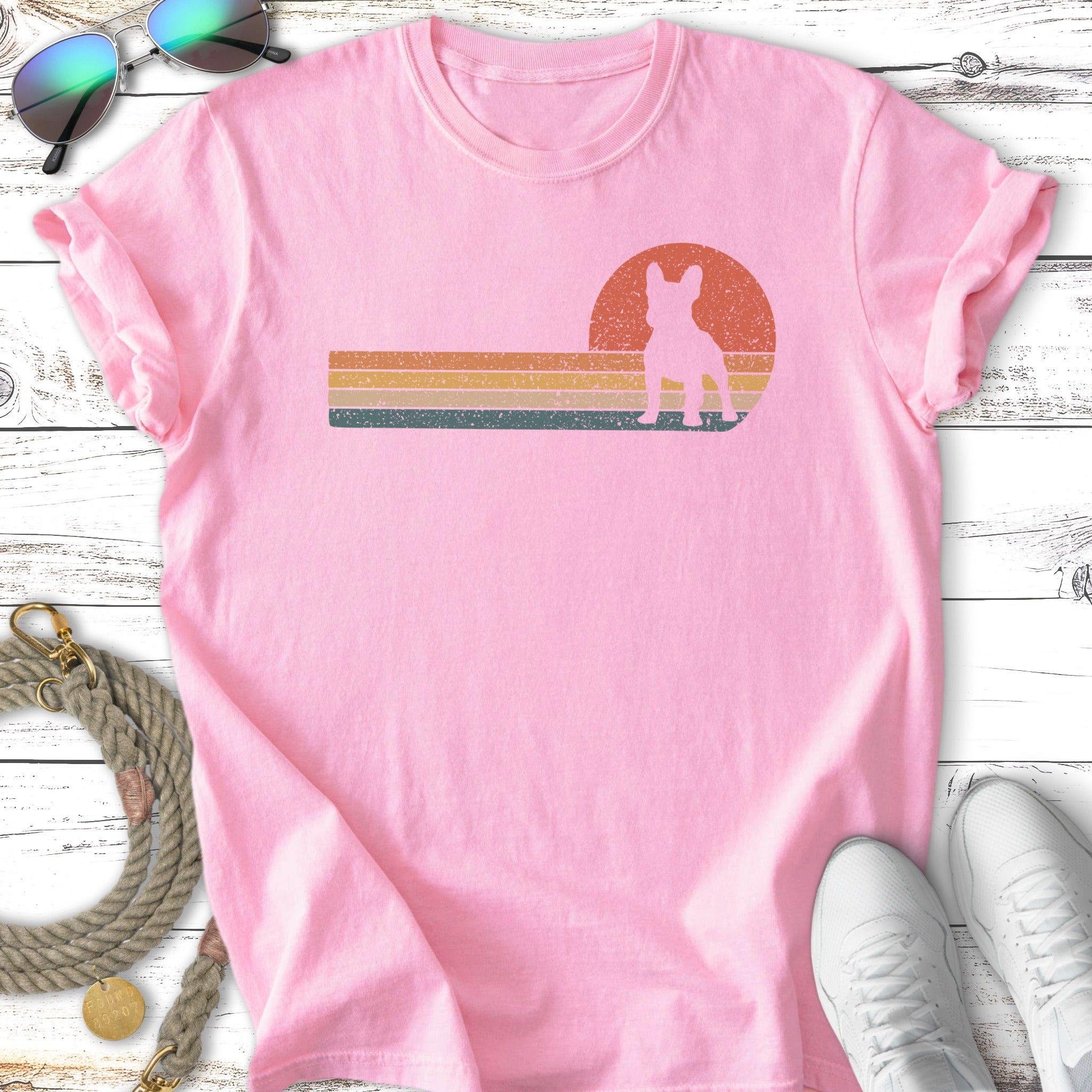 Pink t-shirt with a silhouette of a French bulldog against a retro sunset graphic.