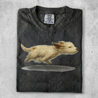 T-shirt with watercolor painting of a fluffy tan dog running.