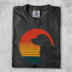 Dark t-shirt with a dog silhouette against a sunset graphic.