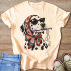 Dalmatian dog wearing sunglasses and a crochet scarf holds yarn and crochet hook.